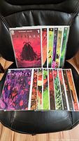 Full set of 15 Dark Ark comics arranged in two rows on a chair, showing cover art and numbering.