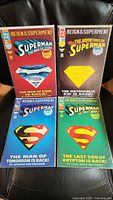 Four die-cut DC Comics from Reign of the Supermen series displayed on black surface, showing colorful covers with Superman shield cutouts.
