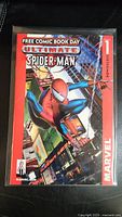 Front cover photo of Ultimate Spider-Man Issue 1 comic book showing Spider-Man swinging in the city with Free Comic Book Day logo and Marvel markings.