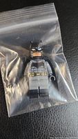 Front view of Lego Batman minifigure in plastic bag showing detailed Batman suit printing.