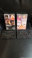 Front view of two Motley Crue audio cassette tapes with cases and tapes visible
