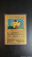 Full view of the Special Delivery Pikachu gold-colored Pokemon card in protective sleeve showing artwork and card details