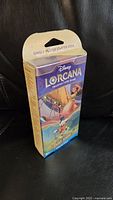 Front view of sealed Disney Lorcana Starter Deck box showing colorful artwork and branding.