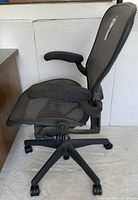 Three-quarter side view of entire chair showing mesh seat, back, frame and base
