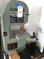 Front view of Delta bench top band saw showing label and worktable.