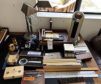 Overview of lot on desk surface showing Motorola radio, desk lamp, paper trays, heater, magnifying glass, rulers, pens and inkwell