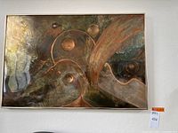 Front view of framed acid etched copper artwork with abstract curves and circles in silver metal frame