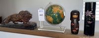 Full grouping photo showing lion statue, globe on stand, Asian girl doll, and black lacquer candle holder