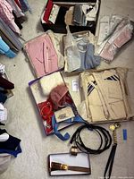 Overview of three packaged sweater sets, cream sweater set unboxed, assorted gloves and purses