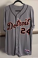 Front of gray Detroit Tigers jersey with 'Detroit' lettering and number 24 on front, buttoned up, on hanger.