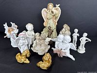 Wide shot of all angel figurines arranged together on black background