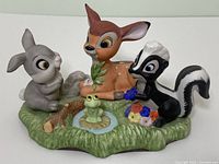Front angle of the full Bambi figurine showing Bambi, Thumper, Flower, and frog on grass base with pond and flower details.