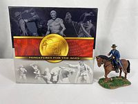 Miniature figurine of Ulysses S. Grant posed on horseback with Conte Collectibles branded packaging visible behind.