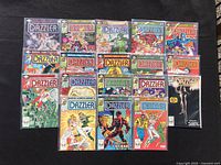 Photo of 19 Dazzler Marvel Comics issues laid out on black surface, showing colorful front covers with various superhero poses and Marvel branding.