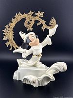 Front and side views of the Disney Fantasia Sorcerer's Apprentice Mickey Mouse figurine showing detailed gold star swirls and wave base.