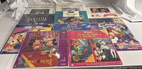 Full display of 10 Disney LaserDiscs laid out on white cloth. Covers include Mary Poppins, 20,000 Leagues Under the Sea, Fantasia, Treasure Island, The Light in the Forest, Prince and the Pauper, and Disney Sing Along Songs.