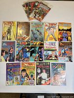 Top-down view of Ms. Tree detective comic series and other comics laid flat on table, showing front covers.