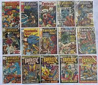Fifteen comics laid out in three rows on fabric background