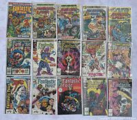15 Marvel Fantastic Four comic book front covers arranged in a 3x5 grid on a floral tablecloth, each in a clear plastic sleeve.