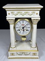 Full view of white and gold Franklin Mint mantle clock with detailed floral decoration and columns.