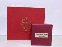 Red and maroon boxes with gold logos and labels indicating John Jenkins Designs and the Tradition line.