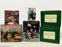 Collection of King & Country original toy soldier boxes and miniatures displayed, including Napoleon in Egypt series box and others.