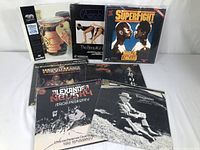 Assorted miscellaneous laserdiscs laid out on a white surface showing covers from wrestling, classical music, and other categories.