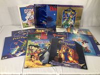 Lot of Disney laser discs arranged side-by-side showing the assortment including Lady and the Tramp, Peter Pan, The Jungle Book, Beauty and the Beast, Cinderella, and The Little Mermaid.