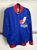 Front view of royal blue Montreal Expos jacket with red collar, cuffs, hem, and large embroidered logo visible.