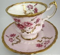 Side view of pink Paragon teacup and saucer with gold accents and pink floral designs