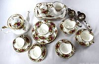 Full set including teapot, creamer, sugar bowl, 6 teacups with saucers, 6 side plates, 2 tea strainers on white background.