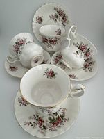 Four Royal Albert Lavender Rose teacups and saucers arranged showing floral design and gold trim details.