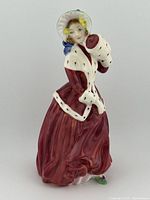 Front and side views of the Royal Doulton Christmas Morn HN 1992 figurine showing the detailed painting and condition of the porcelain piece.