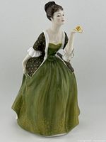 Front view of the Royal Doulton 'Fleur' HN2368 figurine depicting the woman holding a yellow rose and wearing a green dress.