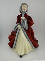 Front view of the Royal Doulton Rachel HN 2936 porcelain figurine, showing woman in red cloak and cream dress.