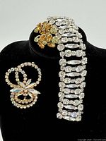 Three-piece Sherman jewelry set displayed on black presentation bust showing bracelet, brooch and earrings.