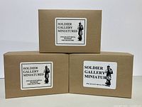 Three plain brown boxes stacked, each labeled with Soldier Gallery Miniatures branding