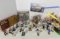 Front and main overview of Timpo Wild West figurine lot with multiple plastic Cowboys and Indians in standing and mounted poses, with original packaging in background.