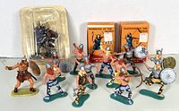 Front view of fourteen (14) Viking warrior figures posed with two still boxed Marx Warwick figures: Ketil and Haakon. Figures painted in multiple colors with detailed weapons.