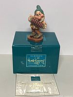 Figure of Bashful with accordion on green Walt Disney Classic Collection box and certificate of authenticity in front.