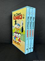 Three volumes in a slipcase with colorful cover artwork featuring Disney's Donald Duck characters photographed from an angle.
