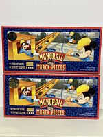Two unopened boxes of Walt Disney Monorail Track Pieces featuring 4 straight beams and 4 support columns each.