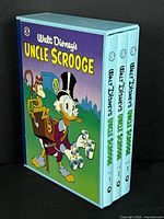 Three hardcover volumes of Walt Disney's Uncle Scrooge comics in slipcase, showing full set from volume 1-3.
