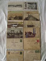 Overview of twelve assorted antique postcards with various scenic, architectural and illustrated images. Stamps and cancellations with dates from early 1900s visible.