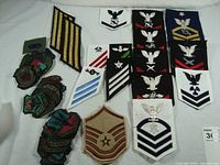 Overview photo showing assortment of Navy and Air Force military insignia patches including rank chevrons and squadron badges