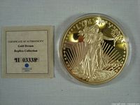 Photo showing the coin inside its acrylic snap case alongside the certificate of authenticity for the Gold Dream Replica Collection.