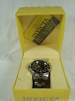 Invicta Pro Diver watch displayed inside its yellow branded box with instruction booklet and warranty card.