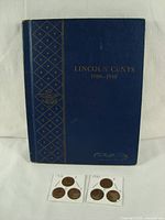 Front cover of blue Whitman album labeled ‘Lincoln Cents 1909–1940’ with gold lettering, plus loose 1926 and 1930 pennies in 2x2 holders.