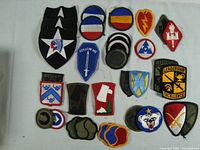 Full view of 25 assorted US Army divisional and leadership insignia patches.