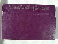 Photo of purple outer cardboard envelope with 'United States Proof Set 1985' embossed in silver, showing wear and creases.